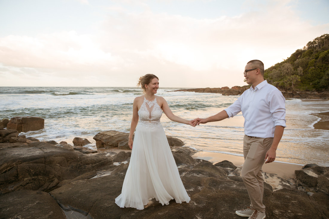 bride and groom on a beach holding hands